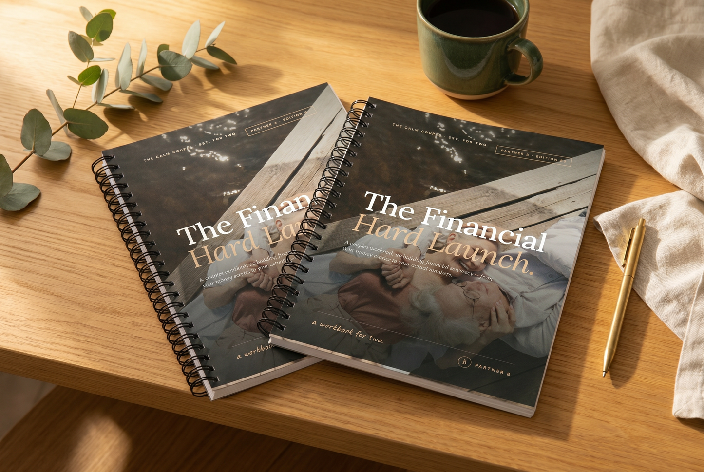 The Financial Hard Launch spiral-bound couples workbook set, Partner A and Partner B, on a warm wooden desk